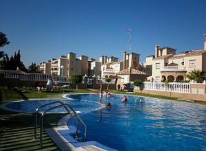un gruppo di persone in una piscina di Chalet de 8 camas a Orihuela Costa