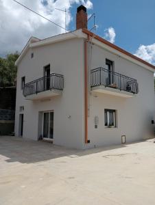 - un bâtiment blanc avec 2 balcons dans l'établissement Appartamento Marianna, à Piazza Armerina
