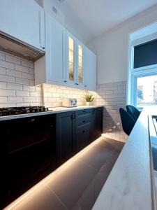 cocina con armarios azules y encimera en The Retreat - Luxury apartment, 2 mins from beach., en Bournemouth