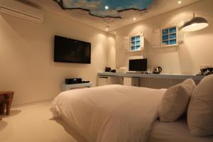 a bedroom with a bed and a tv on the wall at Hotel Pop2 Jongno in Seoul