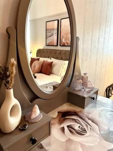 1 dormitorio con espejo y 1 cama. en The Retreat - Luxury apartment, 2 mins from beach., en Bournemouth