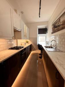 a kitchen with a sink and a counter top at The Retreat - Luxury apartment, 2 mins from beach. in Bournemouth