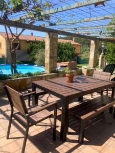 a wooden picnic table and two chairs and a pool at MIRADA A GREDOS in Candeleda