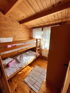 - une chambre avec 2 lits superposés dans une cabane en rondins dans l'établissement Domki Letniskowe Kalem, à Zabin