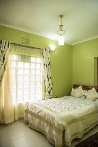 ein Schlafzimmer mit einem großen Bett und einem Fenster in der Unterkunft The Tea Cottage in Karatina