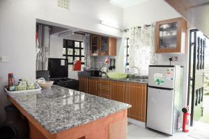 eine Küche mit einer Arbeitsplatte und einem Kühlschrank in der Unterkunft The Tea Cottage in Karatina