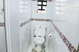 mała łazienka z toaletą i prysznicem w obiekcie The Tea Cottage w mieście Karatina