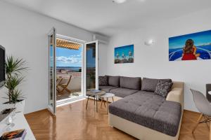 a living room with a couch and a balcony at Newly renovated apartment with a beautiful sea view Emili in Promajna