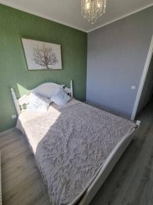łóżko w sypialni z zieloną ścianą w obiekcie Sodų skg. 10 w Możejkach
