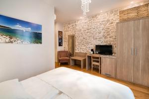 a bedroom with a bed and a desk and a tv at Tifani Luxury Rooms in Split