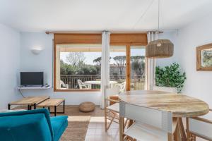 a dining room with a table and chairs and a window at Apartamentos CASA MAREA La Fosca parking y piscina in Palamós