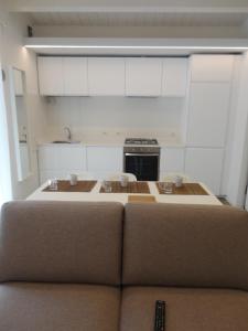a living room with a couch in front of a kitchen at CASA KLIMT vicinissima al mare parcheggio privato gratuito se disponibile in Pescara