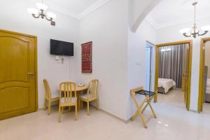 a room with a table and chairs and a television at Esra Hotel Apartment in Khasab