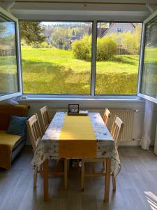 einen Tisch und Stühle in einem Zimmer mit einem großen Fenster in der Unterkunft Slunný byt v Jizerských horách 5 postelí in Tanvald