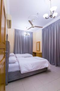 Esra Hotel Apartment في خصب: غرفة نوم بسرير كبير مع ستائر ارجوانية