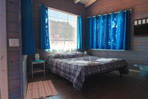 a bedroom with a bed and a window with blue curtains at Mandorleo in Belpasso