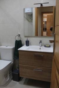 a bathroom with a sink and a toilet and a mirror at Oualidia City Centre Cosy Apartment, Free WIFI in Oualidia