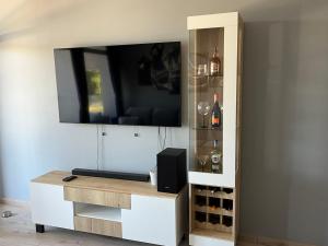 a entertainment center with a tv and wine bottles at Luksusowy apartament Charzykowy in Charzykowy
