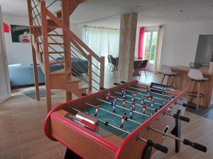 een kamer met een tafelvoetbaltafel en een trap bij Jolie maison entre Terre et Mer in Lithaire