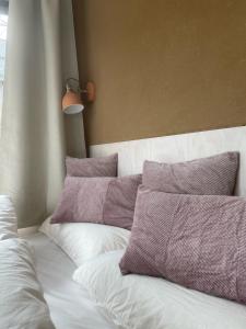 a bed with purple and white pillows on it at Cozy Cabins I Tiny House Seecontainer in Hahnenklee-Bockswiese