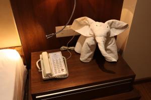 a stuffed elephant on a desk next to a phone at Pride Hotel Bhopal in Bhopal