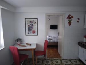 a kitchen with a table and red chairs and a room at Apartments Villa Anton in Poreč