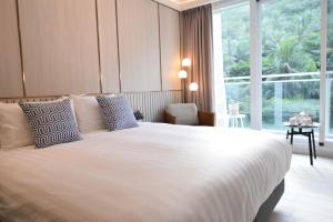 a bedroom with a large bed and a large window at Hayata Hotel in Hengchun South Gate