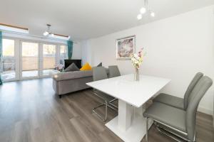 uma sala de estar com uma mesa branca e um sofá em Greenfield's Marlborough Grove Modern 3 - Bedroom Home, Langley em Langley Marish