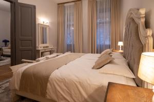1 dormitorio con 1 cama grande con sábanas y almohadas blancas en Kinsley Apartment 1, en Timisoara
