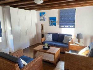un soggiorno con divano blu e sedie in vimini di MY CYCLADIC HOME , 5 min walk to Ornos beach a Ornos