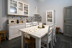uma cozinha com armários brancos e uma mesa com cadeiras em Kinsley Apartment 1 em Timisoara
