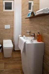 a bathroom with a white sink and a toilet at Kinsley Apartment 1 in Timişoara