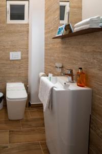 a bathroom with a white sink and a toilet at Kinsley Apartment 1 in Timişoara +12 photos