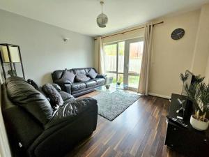 a living room with a leather couch and a glass table at Baltic Townhouse, 4 Bed, Parking - Pass the Keys in Liverpool
