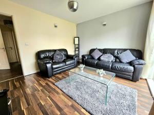 a living room with a leather couch and a glass table at Baltic Townhouse, 4 Bed, Parking - Pass the Keys in Liverpool