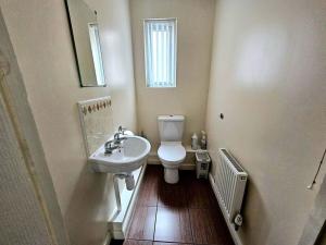 a bathroom with a toilet and a sink and a mirror at Baltic Townhouse, 4 Bed, Parking - Pass the Keys in Liverpool