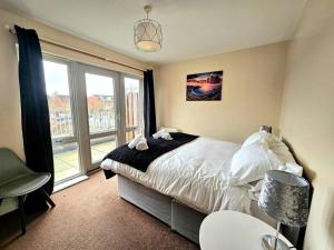 a bedroom with a bed and a large window at Baltic Townhouse, 4 Bed, Parking - Pass the Keys in Liverpool