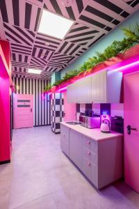 cocina rosa con iluminación rosa en una habitación en VICE CITY Hostel, en Wroclaw