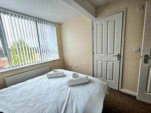 a bedroom with a bed with two towels on it at Baltic Townhouse, 4 Bed, Parking - Pass the Keys in Liverpool