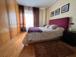 a bedroom with a bed with a purple headboard and a rug at VibesCoruna - Rios 6 in A Coruña