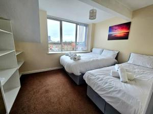1 dormitorio con 2 camas y ventana en Baltic Gem 4 Bedroom Townhouse with free parking en Liverpool