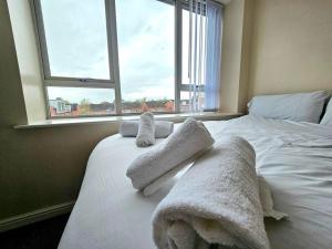 a bedroom with a white bed with towels on it at Baltic Townhouse, 4 Bed, Parking - Pass the Keys in Liverpool