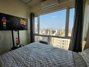 ein Schlafzimmer mit einem Bett und einem großen Fenster in der Unterkunft Makati Penthouse with Stunning City Skyline View in Manila