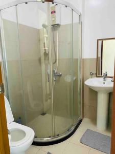 a bathroom with a shower and a toilet and a sink at Makati Penthouse with Stunning City Skyline View in Manila