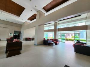 a lobby with couches and chairs in a building at Makati Penthouse with Stunning City Skyline View in Manila