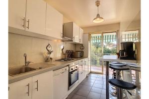 eine Küche mit weißen Schränken und einem Waschbecken in der Unterkunft L'Ermitage - Happy Rentals in Antibes