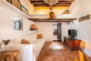 un soggiorno con divano bianco e TV di Can Mateu a Santa Eularia des Riu