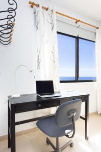 a black desk with a laptop and a chair at Home2Book Casa Malena Tabaiba Seaview in Tabaiba