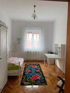 a bedroom with a bed and a table and a rug at Casa Toma M in Baia Mare