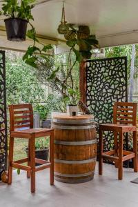 a patio with two chairs and a barrel and a table at The Arcadia - Entire Luxurious English Cottage With Huge Privacy Near CBD in Springfield Lakes